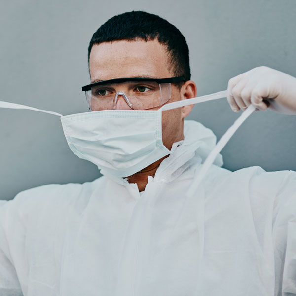 man putting on biohazard suit