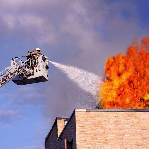 firefighter spraying business fire